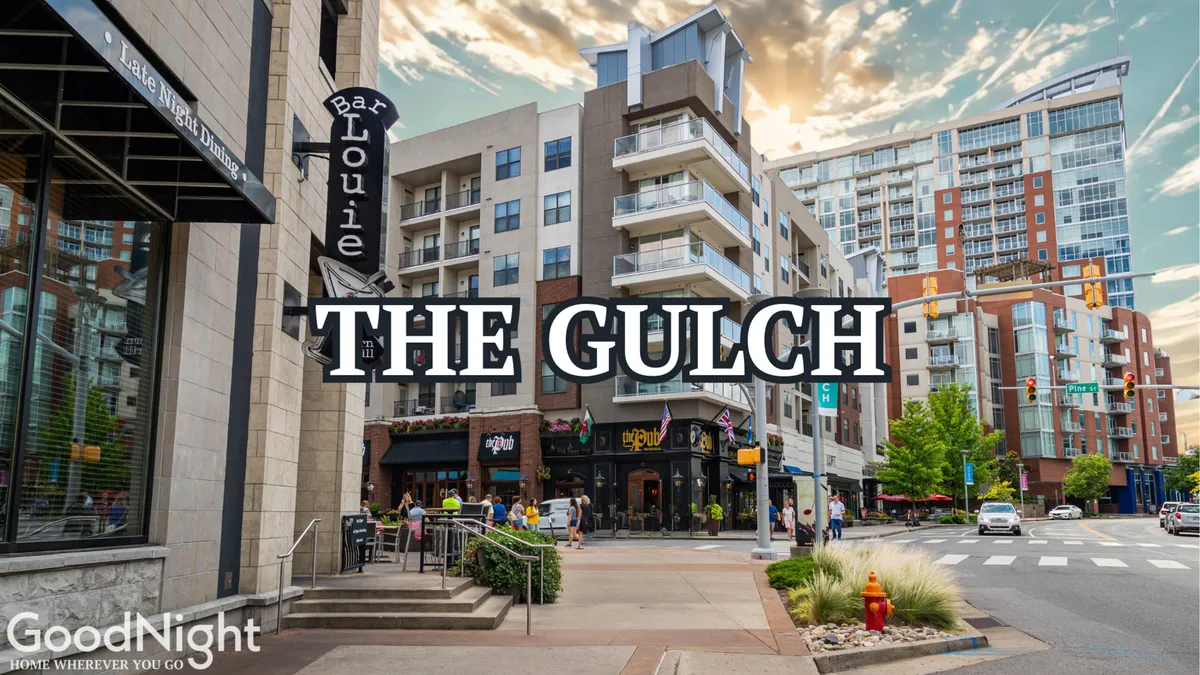 A lively scene in The Gulch, featuring the Bar Louie sign, modern buildings, and groups of people walking and socializing on the street. The street is active with diners, shoppers, and art-seekers, reflecting Nashville’s trendy, urban vibe.